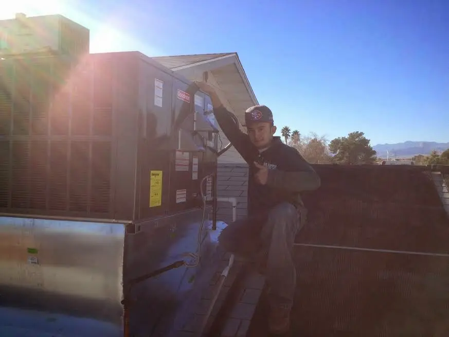 HVAC technician performing Air Duct Repair on a rooftop unit in Fort Hunt